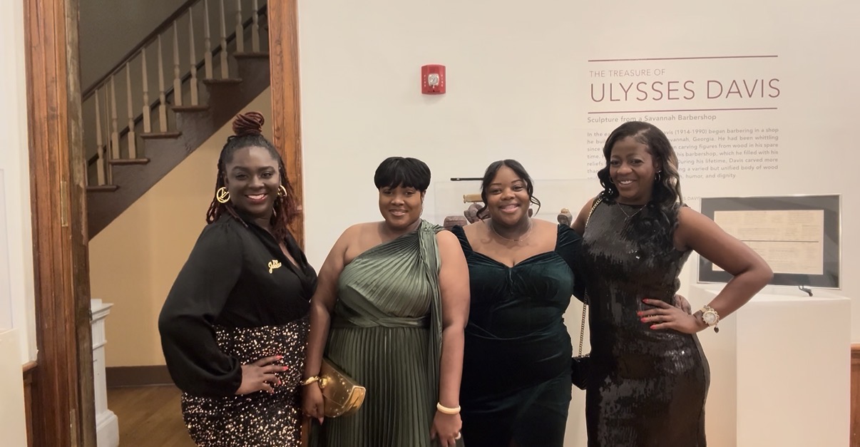Antwonette with three friends at an evening event in a museum gallery